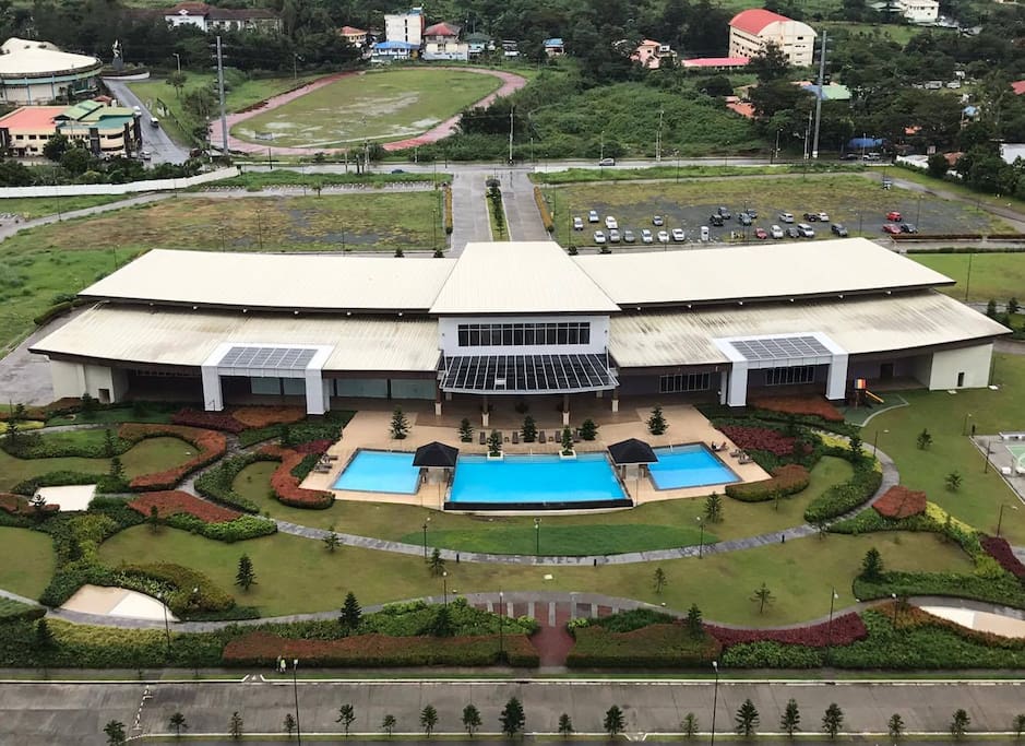 Clubhouse view from the top featuring outdoor and indoor swimming pool, basketball court, tennis court and badminton courts.