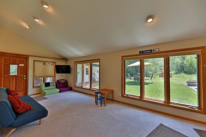 פינת ישיבה אחורית עם מיטת פוטון ומיטת קיר (קווין סייז) (לא מוצגת בתמונה זו), נוף לחצר האחורית בקיץ