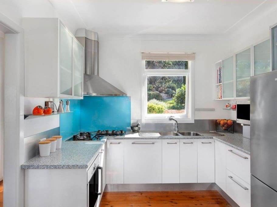 Modern kitchen with gas cooktop and views to yard.