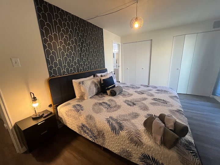 First Bedroom featuring King Sized Bed, Smart TV, and En Suite Attached Full Bathroom w/ Tub