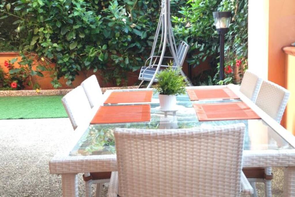 Giardino privato della casa con tavolo per 8 pax, dondolo, sdraia prendisole, barbecue e doccia esterna con acqua calda