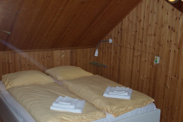 Dormitorio grande en la planta superior con dos camas individuales.