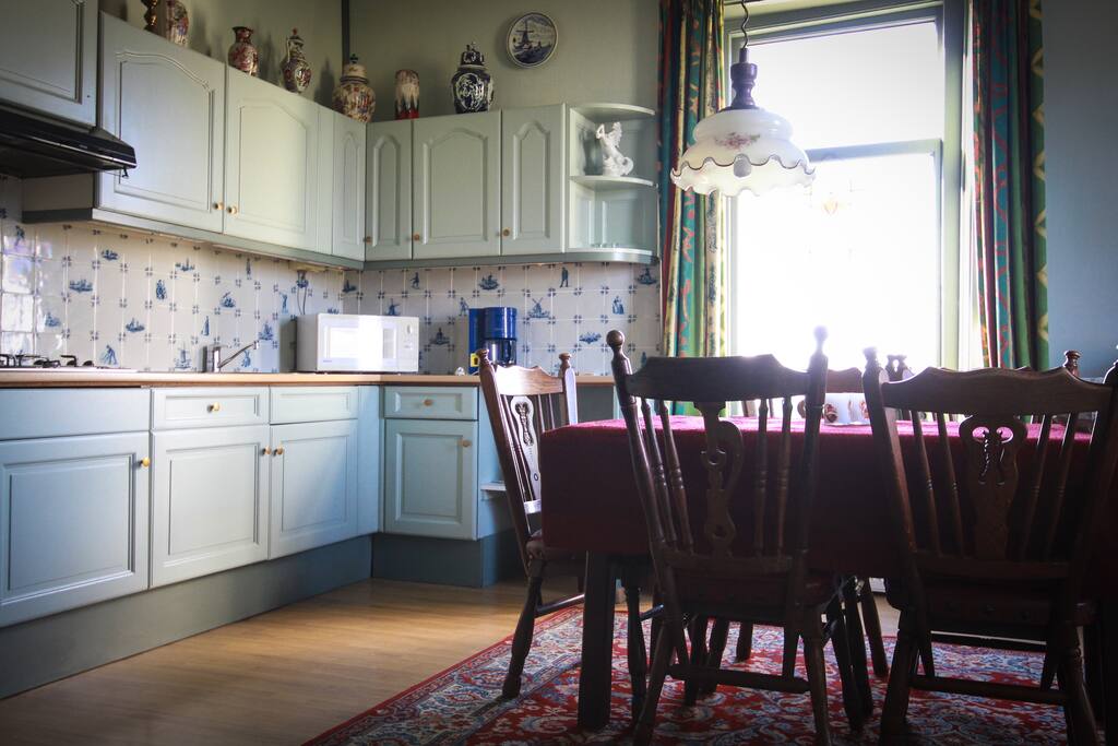 Ingerichte keuken met kookgerei en servies, kookpitten, magnetron en koelkast