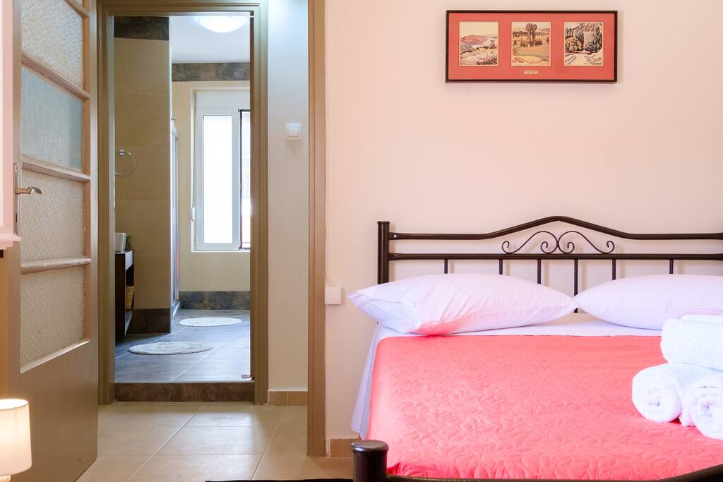 The second bedroom consists of a double bed, a roof fan, a vanity table/desk, and closets