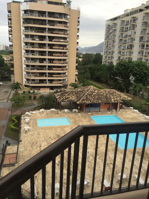 Balcony with a view to a pool at lower level.