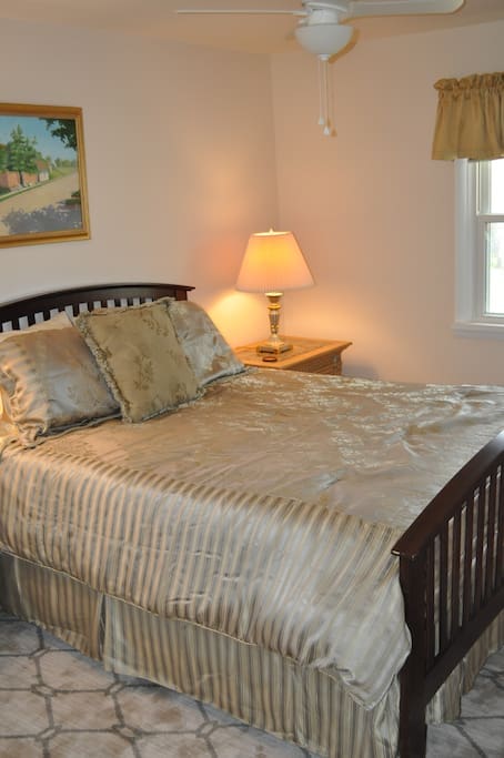 Beautiful and comfortable queen sized bed with side tables and lamps.