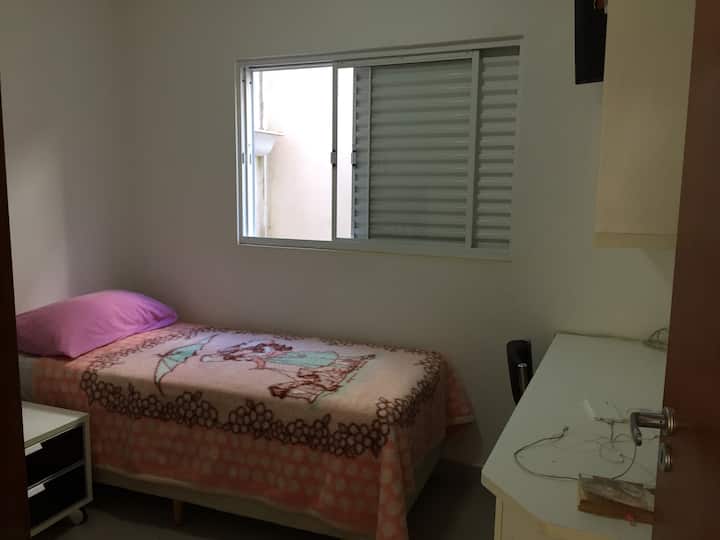 Camera da letto singola con scrivania per lavoro.