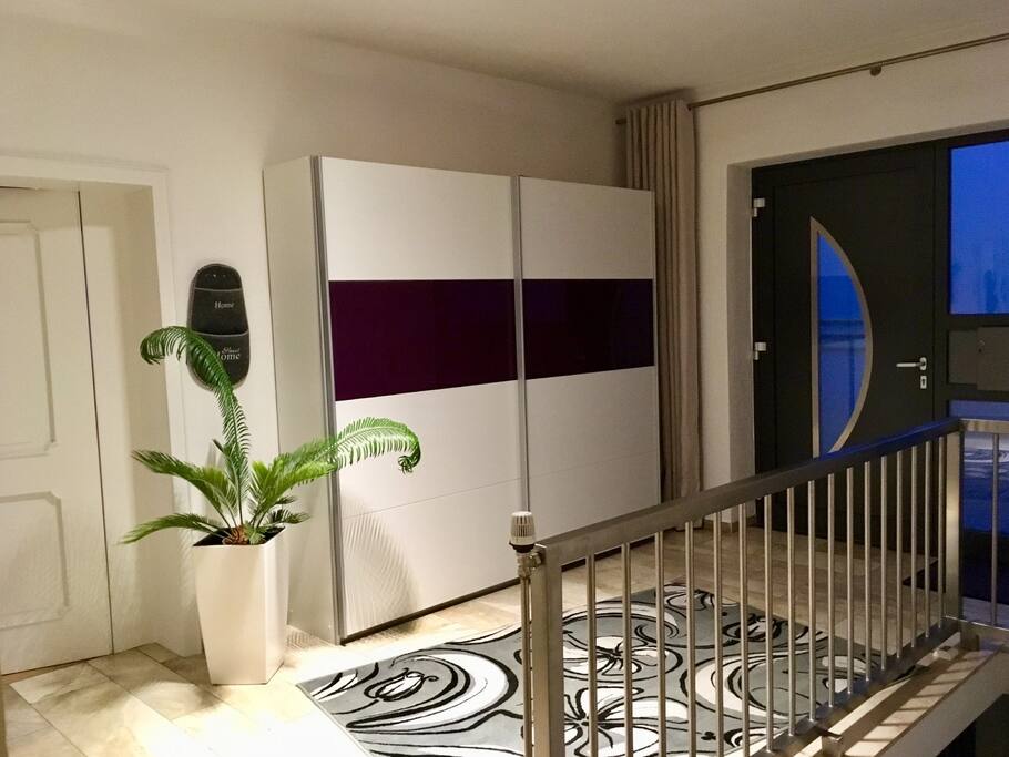 Flur: Tür zum Wohnzimmer, Schrank für Gaderobe und Schuhe, Eingang.