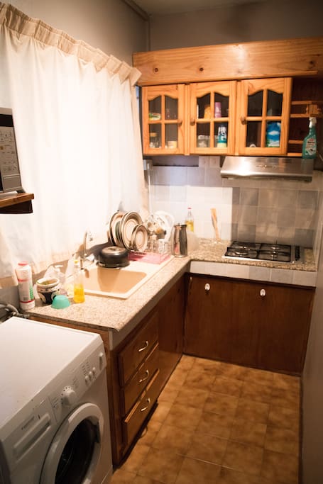 Equipped kitchen with gas stove, electric oven, microwave and a washing machine.