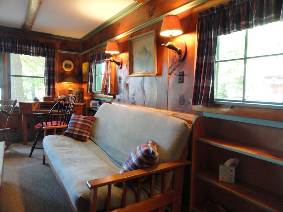 Full-sized futon with thick, comfortable mattress faces the fireplace and folds out to sleep two.