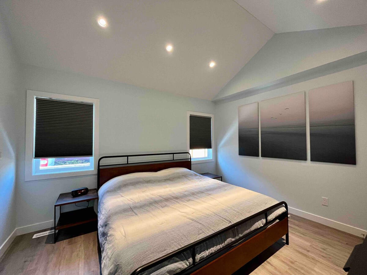 חדר שינה ראשי עם מיטת קינג סייז וחדר רחצה צמוד