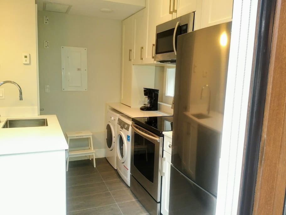 Full kitchen with fridge, stove/oven, microwave, washer/dryer, coffeemaker, dishwasher, pots and pans and kitchenwares.