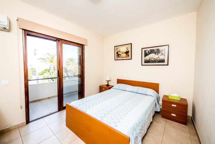 Cama doble en el dormitorio principal con balcón con vistas al mar.