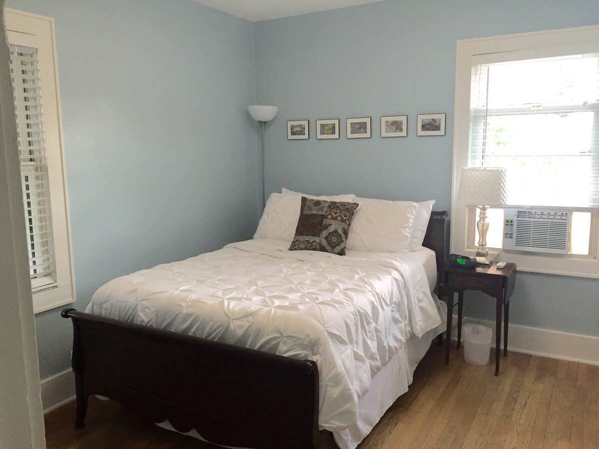 تحتوي غرفة النوم على سرير كامل وخزانة ملابس مع مخزن رفوف ورف ملابس.