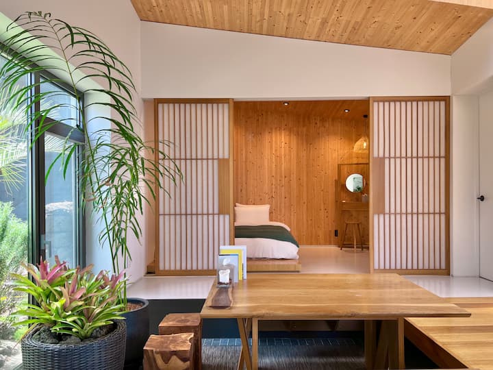 Bâtiment B avec une atmosphère tranquille. Le séjour dispose d'une table à manger basse au centre et vous pouvez voir la pièce derrière elle.  Il n'y a pas de grandes fenêtres dans la pièce, mais vous pouvez ouvrir la porte en direction du salon, vous donnant un sentiment d'ouverture.