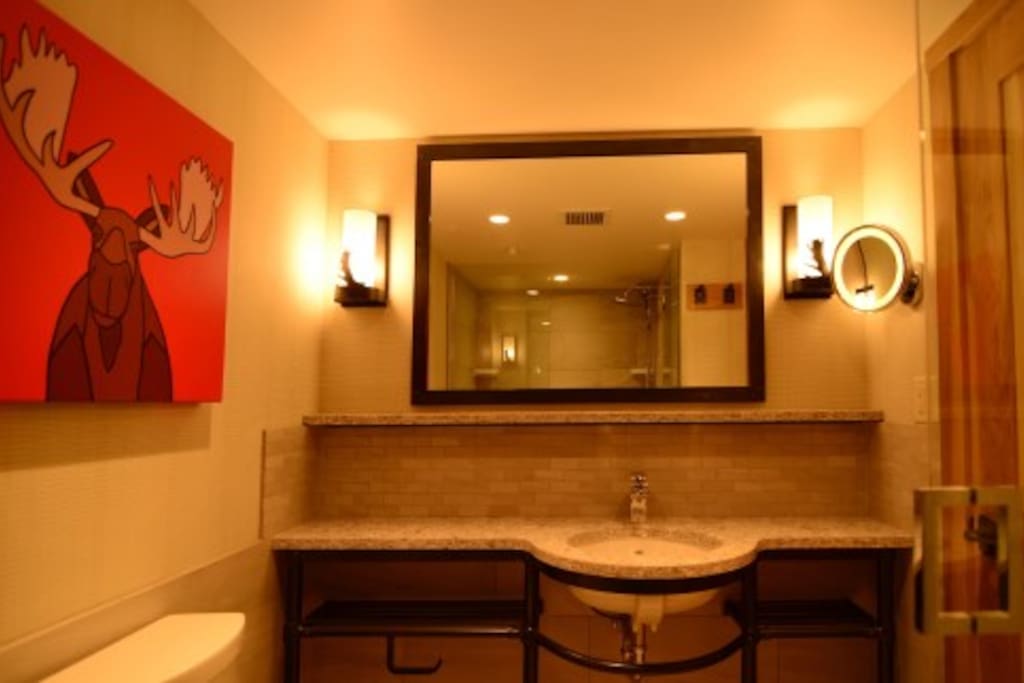 The spacious bathroom features granite countertops and beautiful touches.