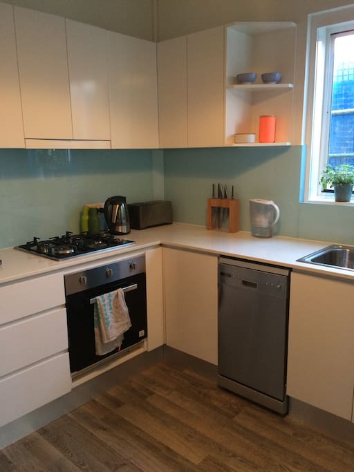 Renovated kitchen with small juliet balcony, washing machine, dishwasher and gas stove.