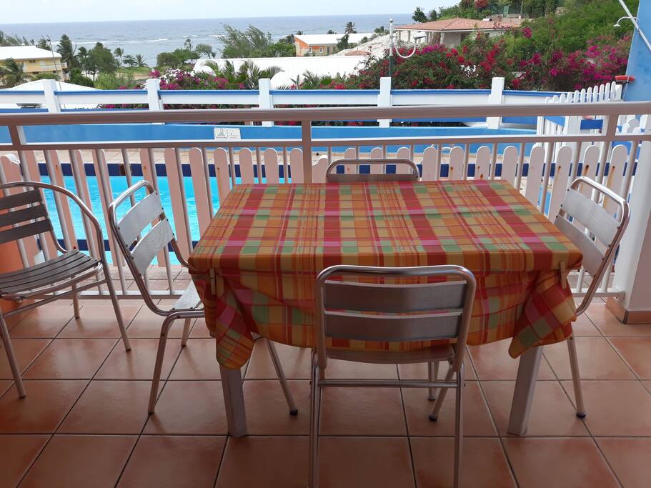 Terrasse face à la piscine et à la mer
