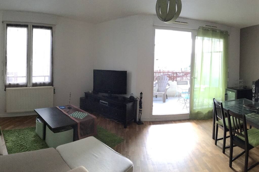 Grande pièce à vivre avec coin salon et coin salle-à-manger, donnant sur un grand balcon (table 4 personnes, fauteuils, plancha...)