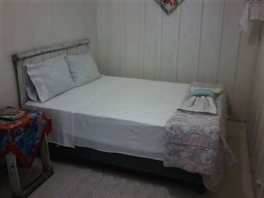 Quarto com cama de casal, roupa de cama e toalhas limpinhas