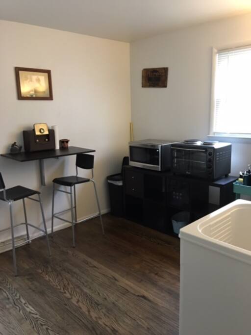 Kitchenette with refrigerator, wet sink, microwave, toaster oven, cook top, free coffee and drop down table.