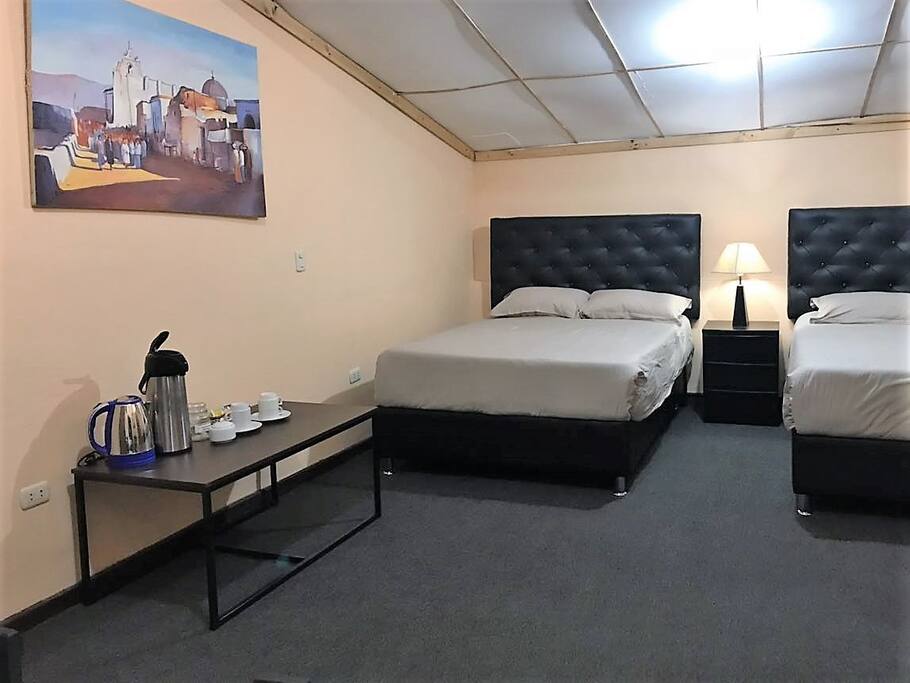 Habitación con baño privado, alfombrada, con dos camas matrimoniales, conexión wifi, con implementos necesarios para que puedan preparar bebidas calientes, optima hasta para 4 huéspedes.