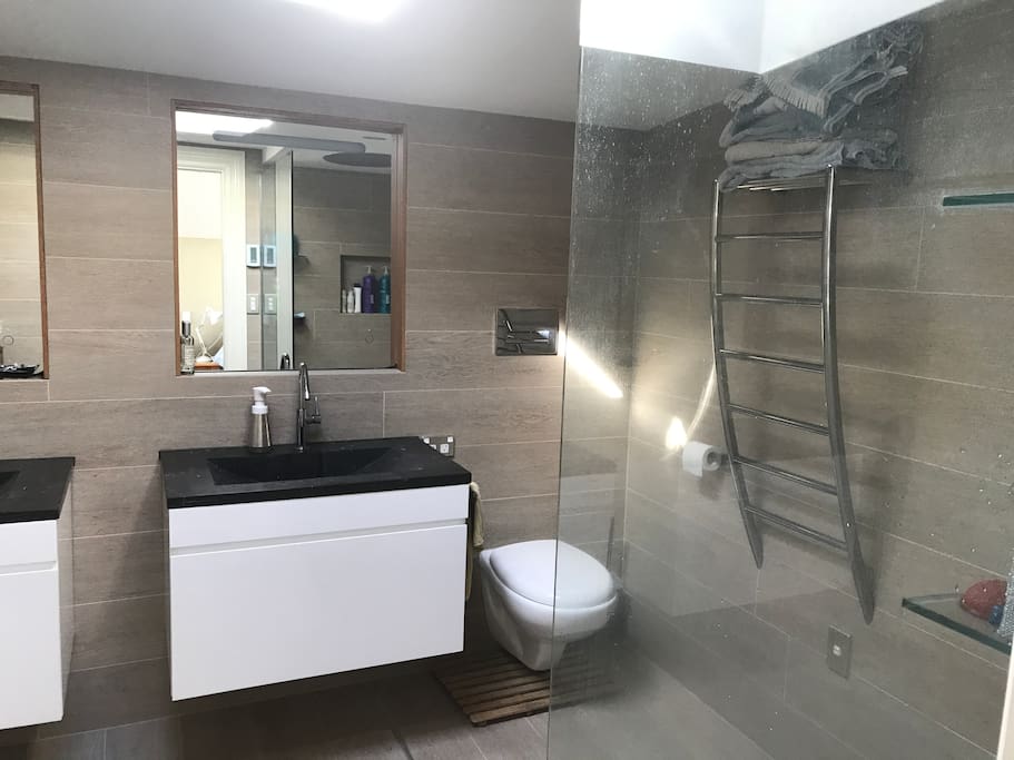 Upstairs ensuite bathroom. Has a washing machine in the corner! His and her sinks, rain shower as well as Methven Satin Jet shower head.
