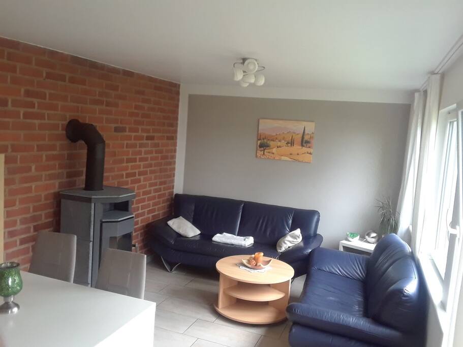 Wohnzimmer mit Kamin und Esstisch