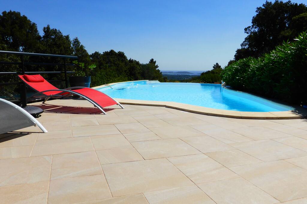 Terrasse piscine avec pergola et barbecue.