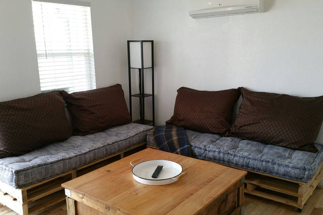 La sala de estar o el sofá se convierten en una cama doble y las almohadas y mantas de las sábanas se encuentran dentro de la mesa de centro