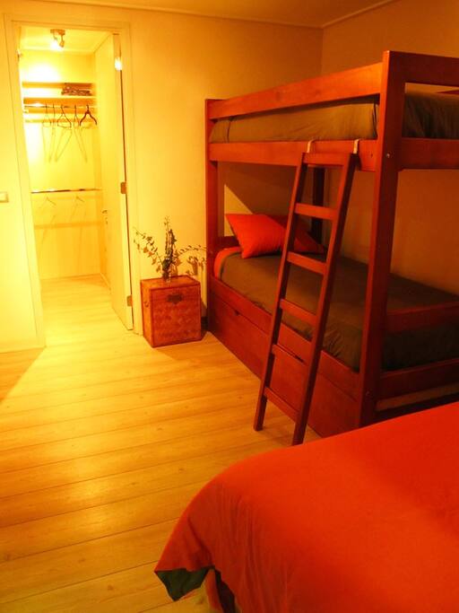 Segundo dormitorio con tres camas y baño en suite.