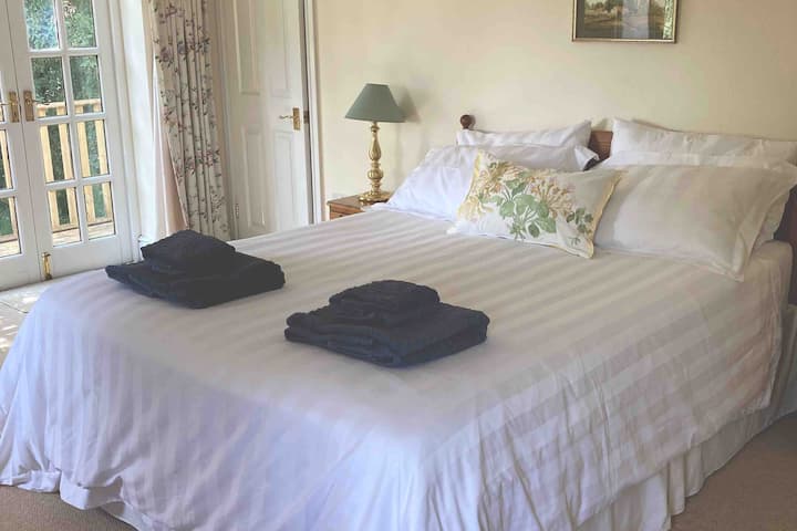 Dormitorio en suite con cama tamaño king y balcón