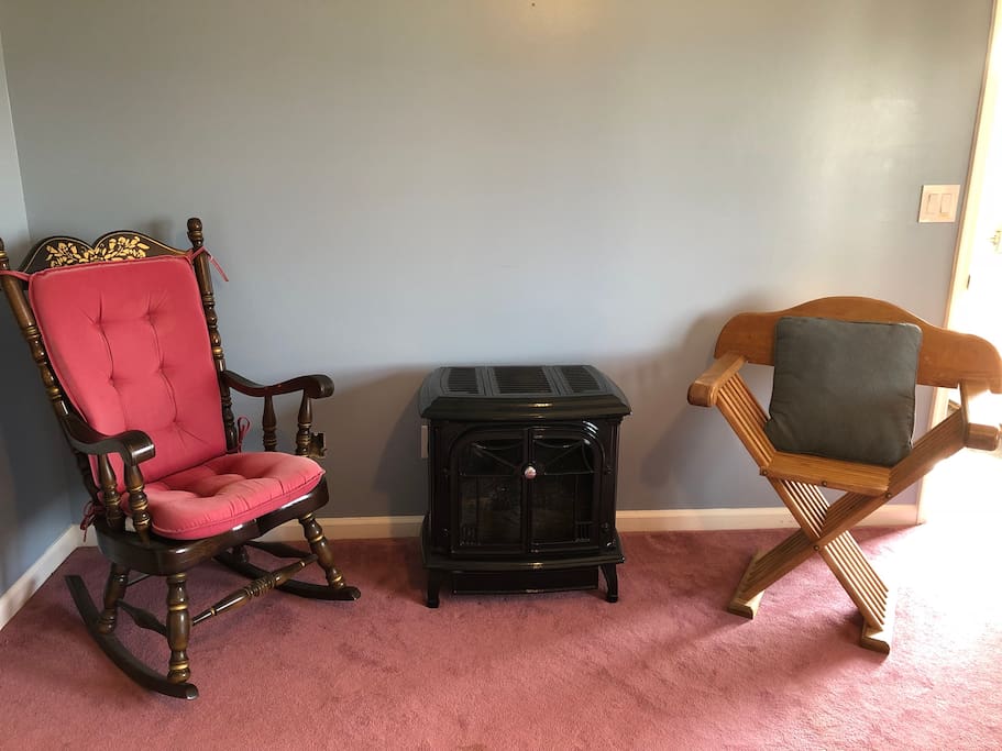 A comfortable sitting area by the fireplace in the room.
