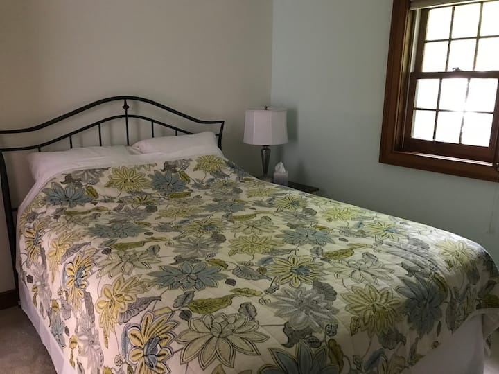 غرفة النوم الثانية: غرفة نوم تضم سرير كوين ومروحة سقف ونافذة مكيف هواء في أشهر الصيف