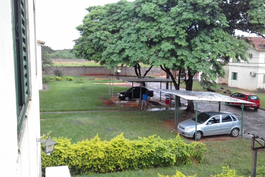 Da sacada do apto, ao olhar para o lado esquerdo, tem essa visão da rua da frente do apto. Vê-se o gramado dos blocos ao lado e o estacionamento.