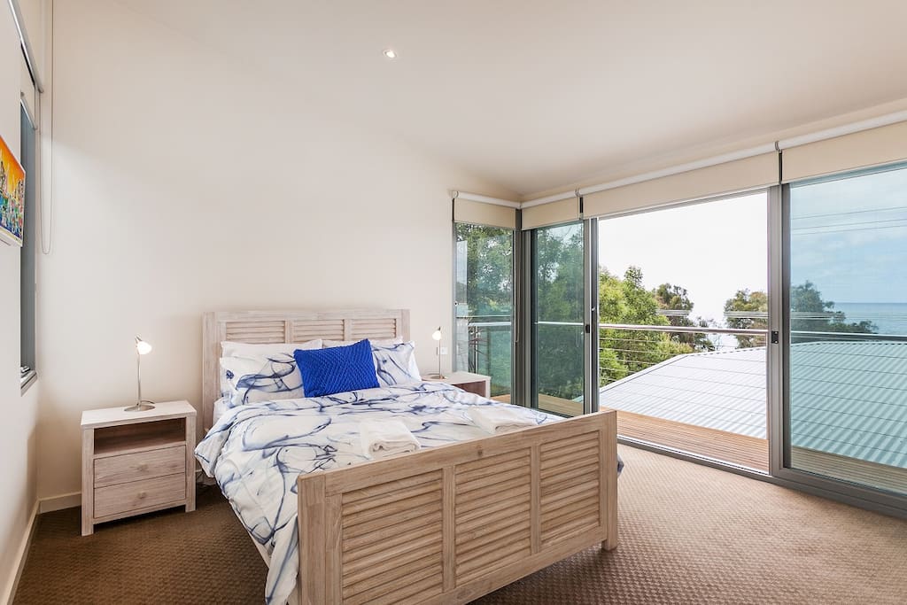 Master bedroom with private deck & ocean views. Upstairs