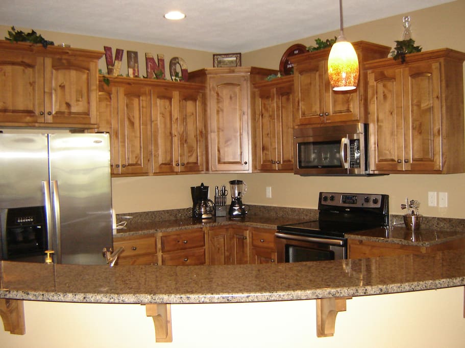 Large kitchen with granite counters and stainless steel appliances.