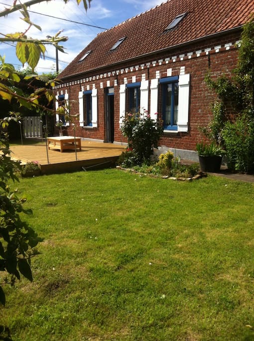 Le jardin devant la maison avec la terrasse en bois,