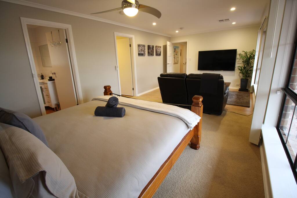 Full view of the studio from the back corner showing the doors leading to the ensuite and kitchen