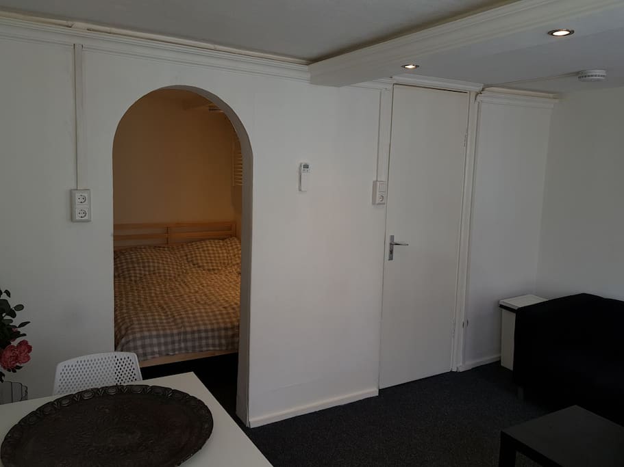 woonkamer met zicht naar het slaapvertrek. daar tref je ook de deur naar het toilet