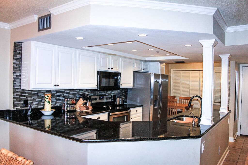 Fully stocked kitchen equipped with pots, pans, cutlery and full spice rack