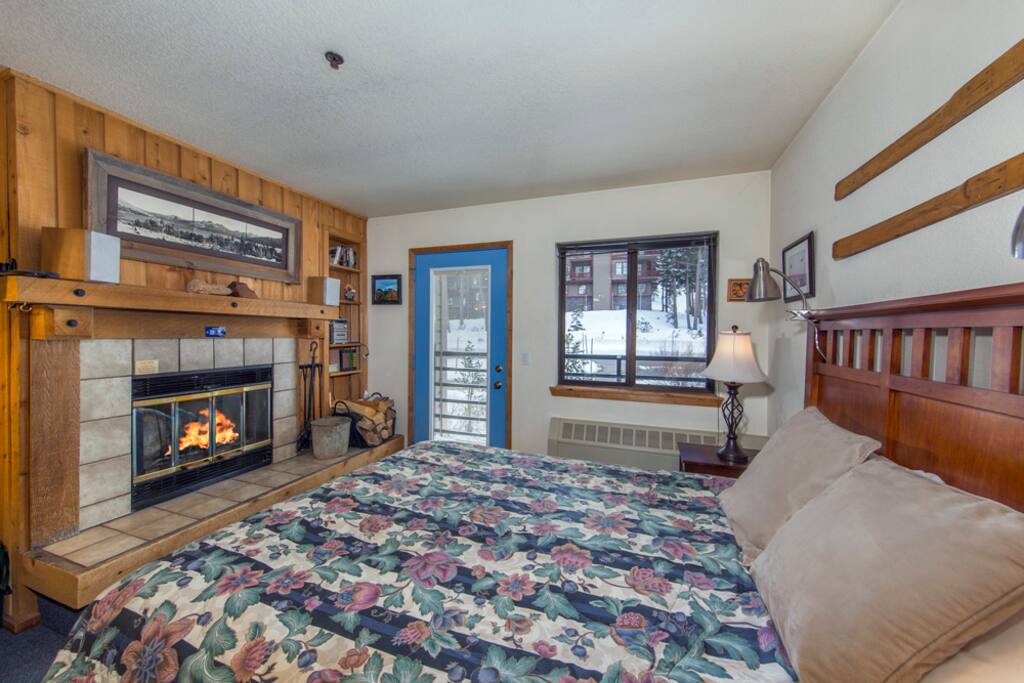 Queen bed overlooking patio, mountains and fire