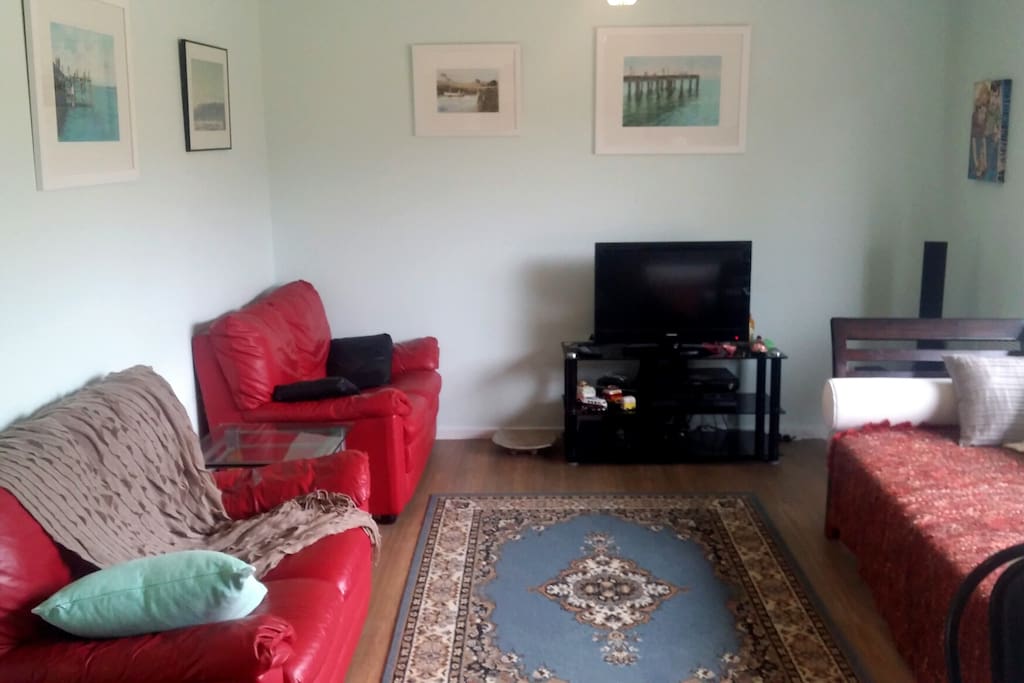 Large comfortable lounge room, plenty of seating, tv, table and chairs, bookcase
