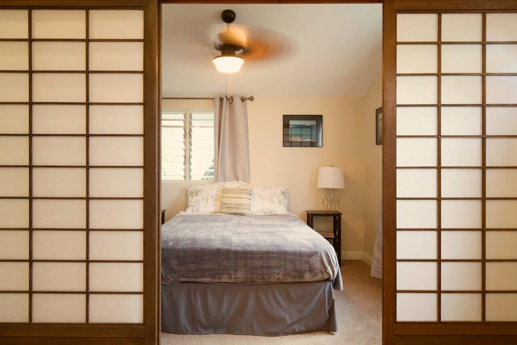 Your bedroom with queen-size bed, ceiling fan, and sliding Japanese shoji doors for privacy.