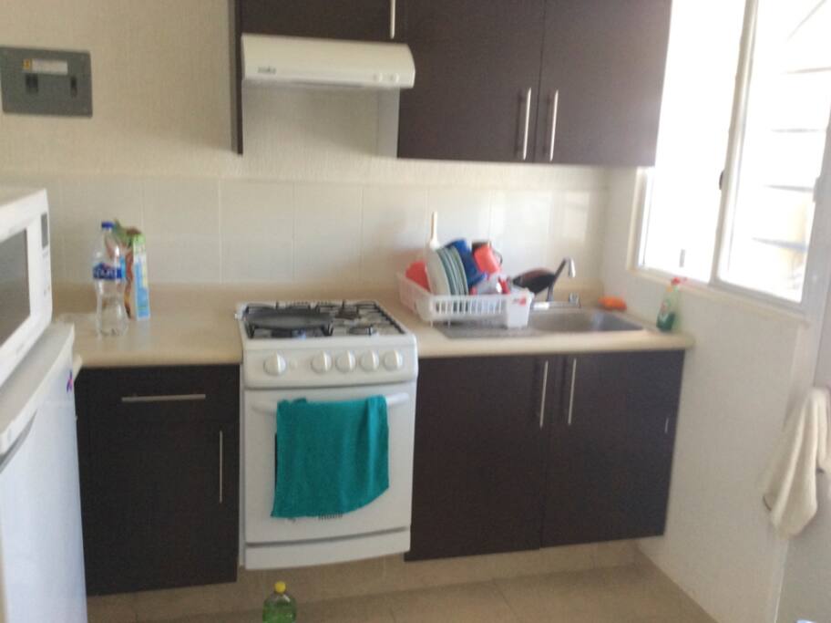 Small Kitchen with small freezer and microwave oven. Pequeña cocina con pequeño refrigerador y horno microondas.