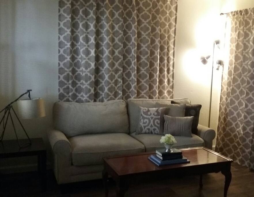 Sit on comfy sofa and gaze out on the well maintained mature trees