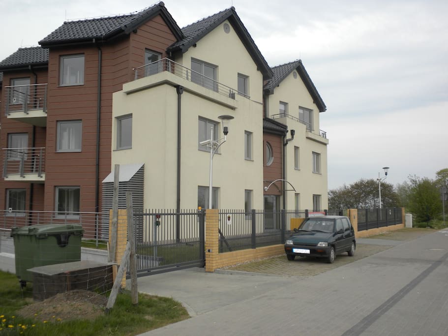 budynek od ulicy z wjazdem do garazu; view from the street with the gate to underground parking