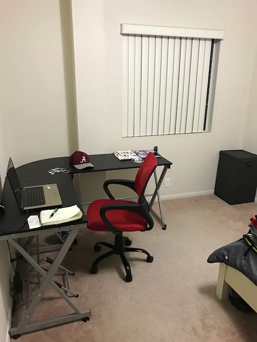 Spacious desk, rolling chair, window, laundry hamper.