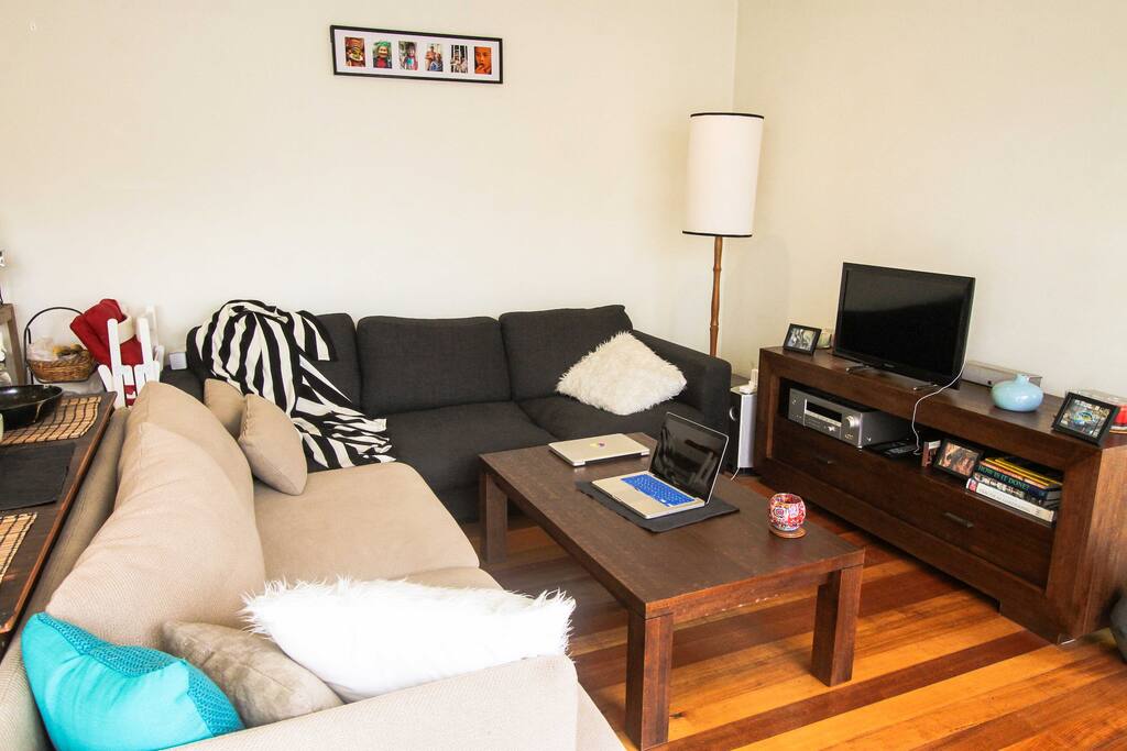 Your cozy living room - updated recently with custom hand-built bookshelf, and black couch replaced with rocking armchair and ottoman
