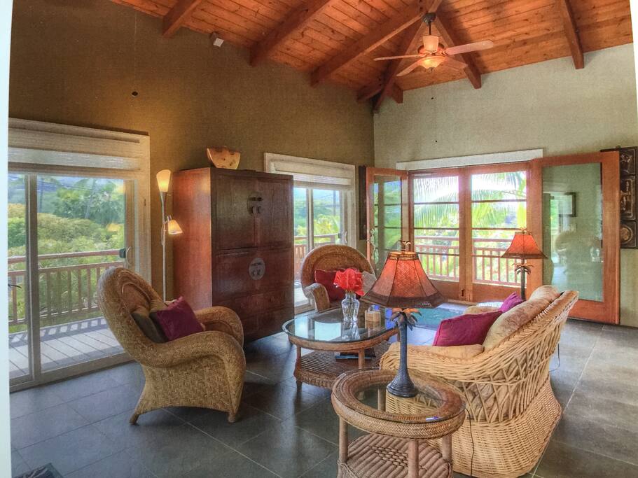 Living room/great room with TV cabinet and views of surrounding mountains and some ocean.
